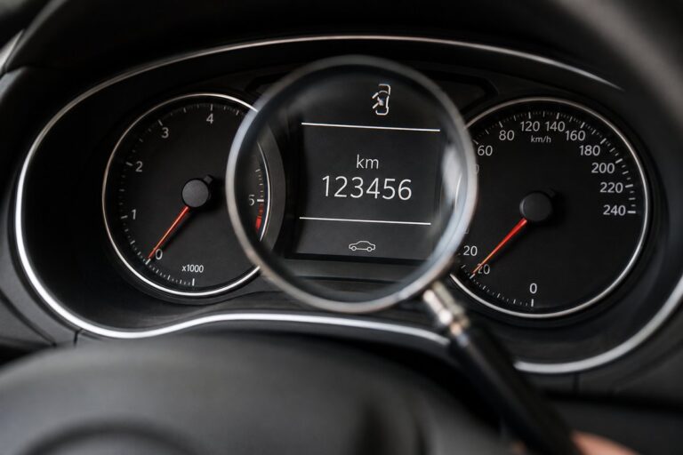 Cuentakilómetros de un coche bajo una lupa para comprobar el kilometraje real